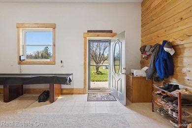 Foyer entrance featuring wooden walls and light tile patterned floors
