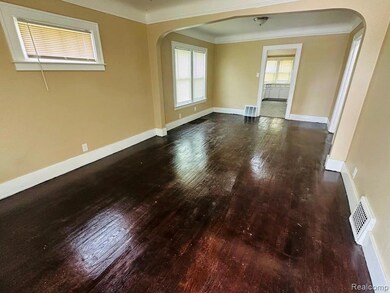 Unfurnished room with arched walkways, dark wood-style floors, and ornamental molding