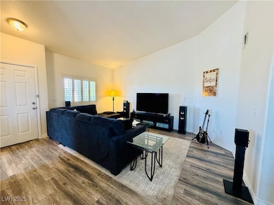 Living area featuring lofted ceiling, visible vent