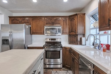 Kitchen featuring stainless steel appliances, tile countertops, and recessed lighting