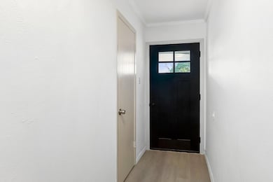 Doorway to outside with crown molding, baseboards