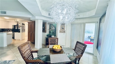 Tiled dining area with a raised ceiling and an inv