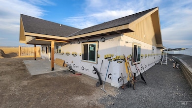 View of side of home with a patio and roof with shingles