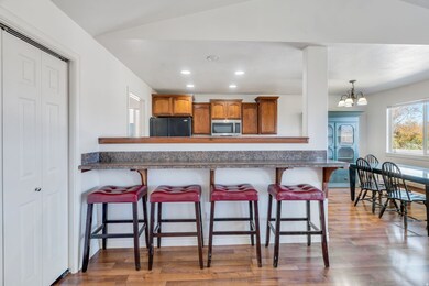 Kitchen featuring brown cabinetry, recessed lighting, light wood-type flooring, plenty of natural light, and dark countertops