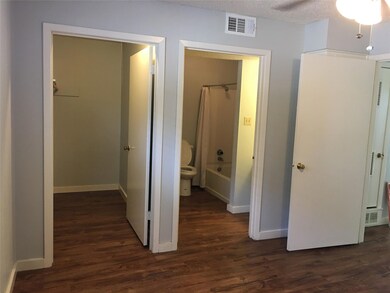 Hall featuring dark wood-style flooring, baseboar