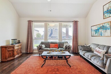Living room featuring hand-scraped hardwood style flooring and lofted ceiling