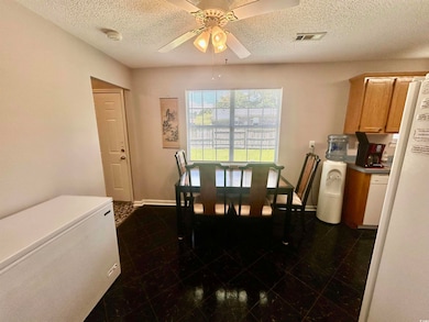 Dining space with ceiling fan and a textured ceiling