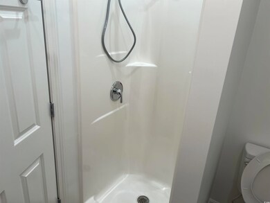 Full bath featuring a stall shower and toilet