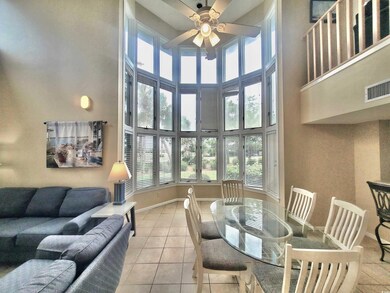 Tiled living room featuring a high ceiling and cei