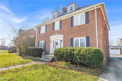 Colonial inspired home with a garage and a front yard