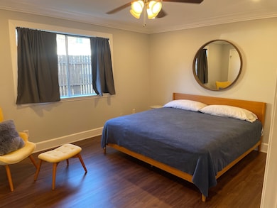 Bedroom featuring crown molding, wood finished floors, and a ceiling fan