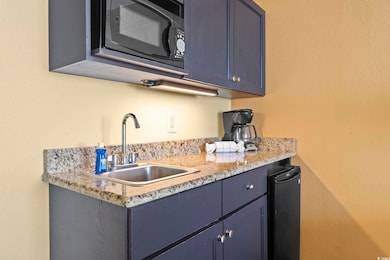 Kitchen with a sink, blue cabinetry, and fridge