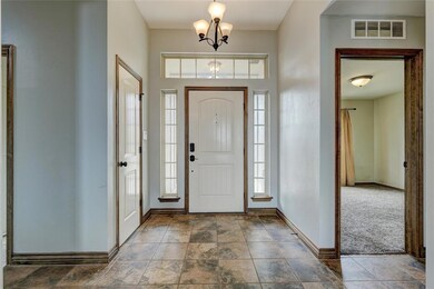 Tiled foyer entrance featuring a notable chandelie