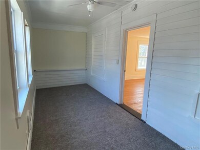 Front bedroom with two new windows, electric heater, and fresh carpeting.