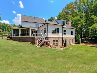 Back of property with stairs, a sunroom, a chimney, and brick siding