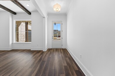 Step into a gracious foyer with smooth ceilings, and gleaming hardwood floors that set the tone for the home’s warm, welcoming elegance.