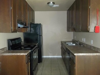 Kitchen featuring black appliances, sink, dark brown cabinets, and tile patterned flooring