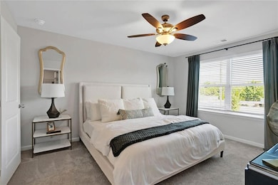 Carpeted bedroom featuring ceiling fan