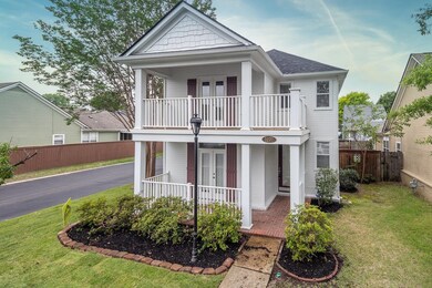 View of front of property with a balcony, french doors, a porch, and a shingled roof