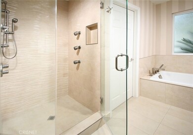Sumptuous en suite master bathroom with state-of-the-art deep ebony vanity with His and Her dual basin sinks, custom tiled back-splash, dual framed dressing mirrors, recessed and designer lighting, tiled soaking tub, oversized frameless glass enclose