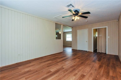 Empty room with crown molding, ceiling fan, and da