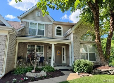 Traditional-style house with covered porch and brick siding