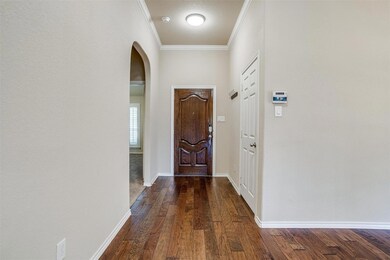 Foyer entrance featuring crown molding and dark ha