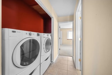 Laundry room featuring light tile patterned floors and separate washer and dryer