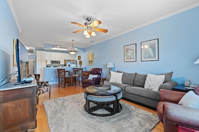 Living room with light wood finished floors, crown