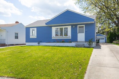 View of front of house with an outdoor structure, a garage, and a front yard