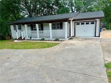 Ranch-style house with covered porch, concrete driveway, an attached garage, and roof with shingles