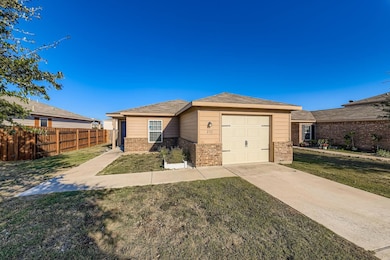 Ranch-style home featuring brick siding, a garage, driveway, and roof with shingles
