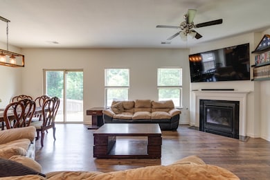 Living room with healthy amount of natural light, wood finished floors, and ceiling fan