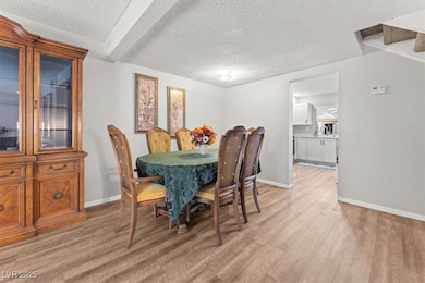 Dining space featuring a textured ceiling and light wood-style floors