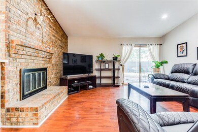 Living room with brick wall, a fireplace, and hard
