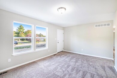 Carpeted spare room with baseboards