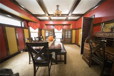 Dining room featuring coffered ceiling, an inviting chandelier, carpet floors, and beamed ceiling