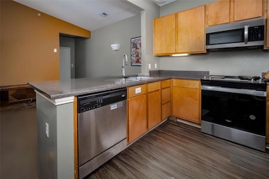 This kitchen features stainless steel appliances and hard-surface floors throughout.