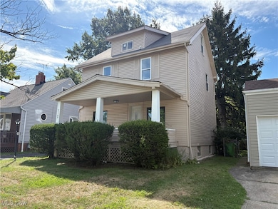 American foursquare style home with a front lawn, a porch, and roof with shingles