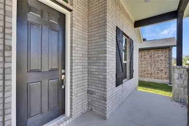 Entrance to property featuring brick siding
