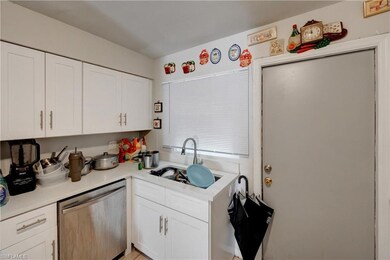 Kitchen featuring a sink, white cabinets, light co