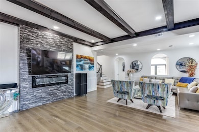 Living room with a large fireplace, beam ceiling, 