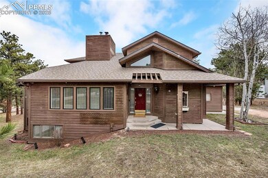 View of front facade with a front yard, roof with shingles, and a chimney