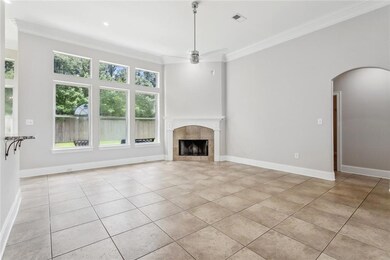 A view of the living room area with a corner fireplace and a wall of windows.