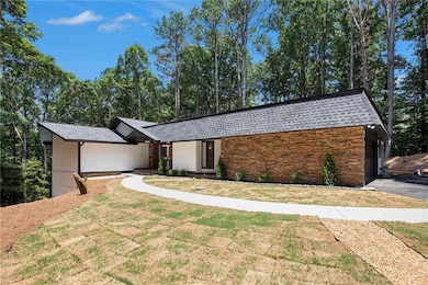 View of front of home with roof with shingles, a front lawn, and stone siding
