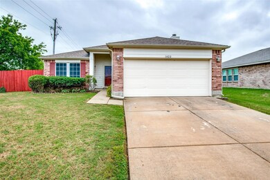 Ranch-style house featuring a garage and a front lawn