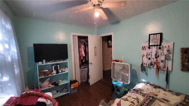 Bedroom with ceiling fan and dark hardwood floorin