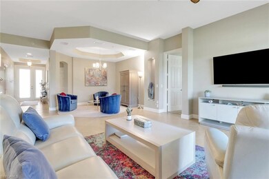 Living area featuring a raised ceiling, baseboards
