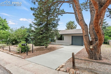 View of front of house featuring concrete driveway, a garage, and roof with shingles