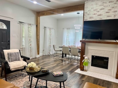 Living room with wood finished floors, a fireplace